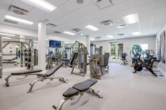 gym featuring visible vents, a paneled ceiling, and baseboards