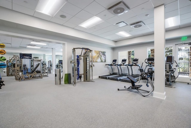 gym with baseboards and a paneled ceiling