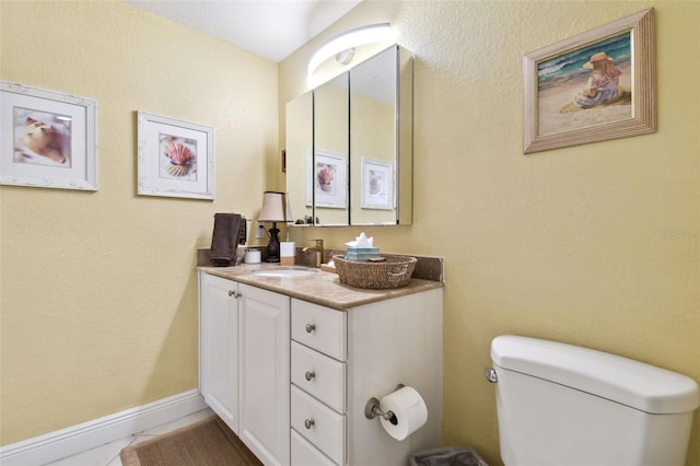 bathroom featuring tile patterned floors, baseboards, toilet, and vanity