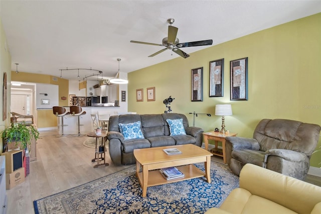 living area with light wood-style flooring, rail lighting, baseboards, and ceiling fan