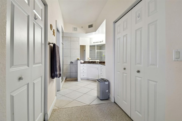 full bathroom featuring a closet, tile patterned flooring, a shower stall, and visible vents