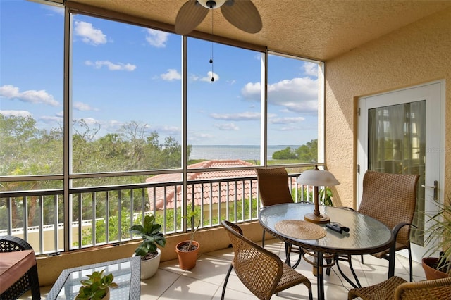 sunroom / solarium featuring plenty of natural light, a water view, and ceiling fan