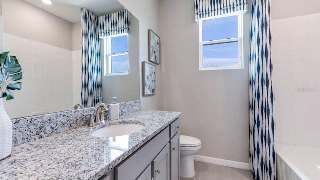 full bath with tile patterned flooring, baseboards, toilet, tiled shower / bath combo, and vanity