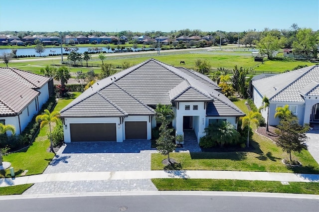 4629 Antrim Dr, Sarasota, FL 34240 - ranch-style house featuring a residential view, a tile roof, a water view, an attached garage, and decorative driveway