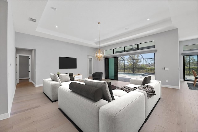 4629 Antrim Dr, Sarasota, FL 34240 - living area with visible vents, baseboards, a tray ceiling, and light wood-type flooring