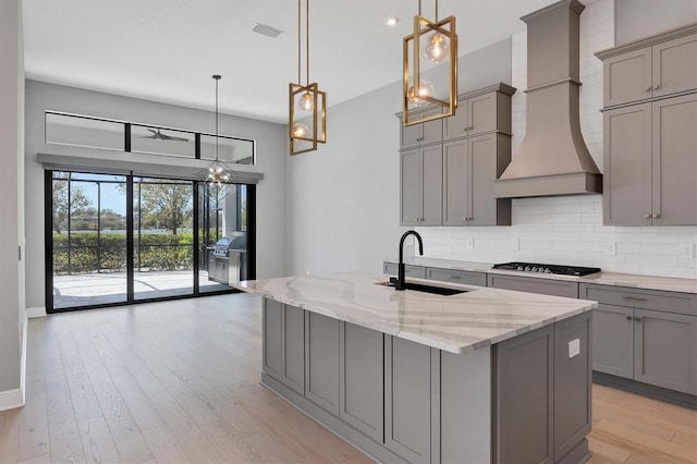 4629 Antrim Dr, Sarasota, FL 34240 - kitchen with a sink, visible vents, decorative backsplash, gray cabinetry, and custom range hood