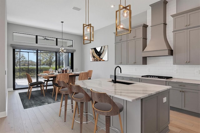 4629 Antrim Dr, Sarasota, FL 34240 - kitchen with a sink, tasteful backsplash, visible vents, gray cabinetry, and custom range hood