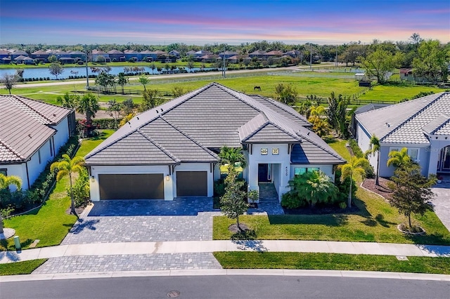 4629 Antrim Dr, Sarasota, FL 34240 - ranch-style home with a tiled roof, stucco siding, a water view, decorative driveway, and a garage