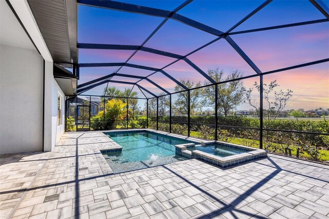 4629 Antrim Dr, Sarasota, FL 34240 - pool at dusk featuring a patio area, glass enclosure, and a pool with connected hot tub