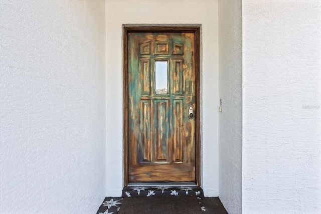 doorway to property featuring stucco siding