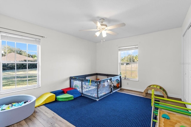 bedroom featuring a closet, a ceiling fan, baseboards, and wood finished floors