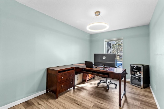 office space featuring baseboards and light wood-style floors