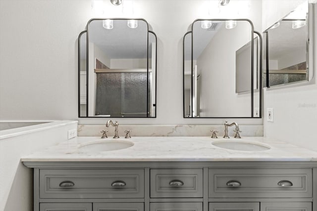 bathroom featuring double vanity, an enclosed shower, and a sink