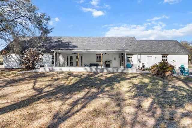 rear view of house with french doors, a ceiling fan, and a patio