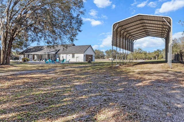 view of yard with a detached carport and driveway