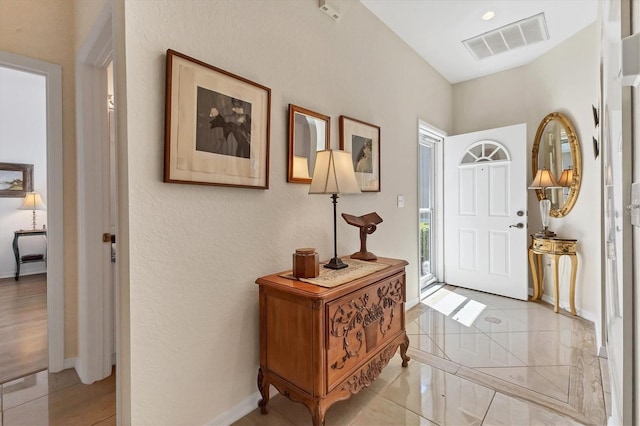 foyer featuring light tile patterned floors, visible vents, and baseboards