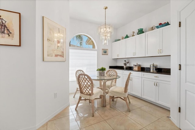 dining space featuring a notable chandelier, baseboards, and light tile patterned floors