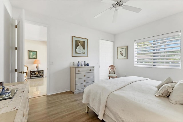 bedroom featuring wood finished floors, baseboards, and ceiling fan