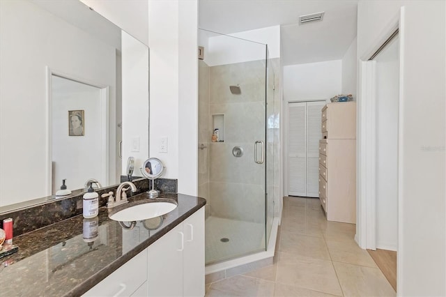 full bath with vanity, tile patterned floors, visible vents, and a stall shower