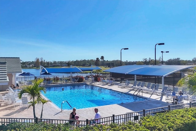 community pool with a patio area and fence