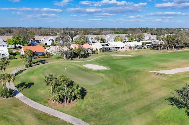 drone / aerial view featuring view of golf course and a residential view