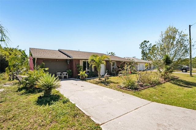 single story home featuring a garage, concrete driveway, and a front lawn