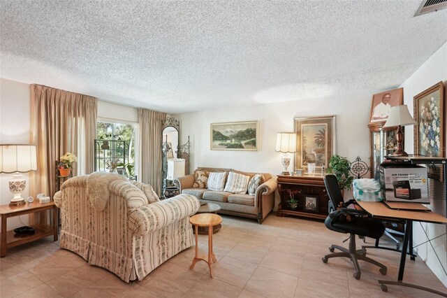 living room with light tile patterned floors, visible vents, and a textured ceiling