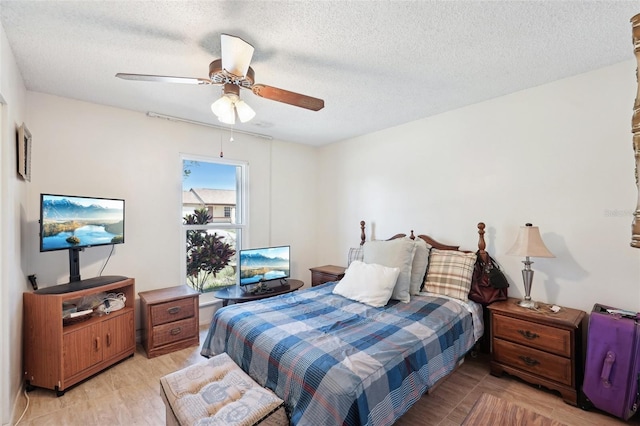 bedroom with a textured ceiling, light wood-type flooring, and ceiling fan