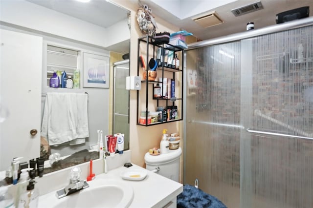 bathroom featuring visible vents, toilet, a stall shower, and vanity