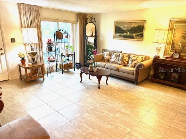 2678 Rock Creek Dr, Port Charlotte, FL 33948 - living room featuring light tile patterned flooring and a textured ceiling