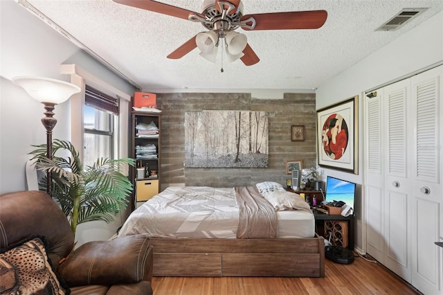 2678 Rock Creek Dr, Port Charlotte, FL 33948 - bedroom with a textured ceiling, wood finished floors, a ceiling fan, and an accent wall