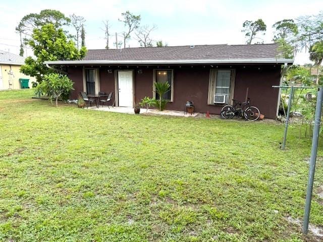 2678 Rock Creek Dr, Port Charlotte, FL 33948 - back of house with a yard, stucco siding, and cooling unit