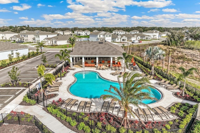 pool with fence, a patio area, and a residential view