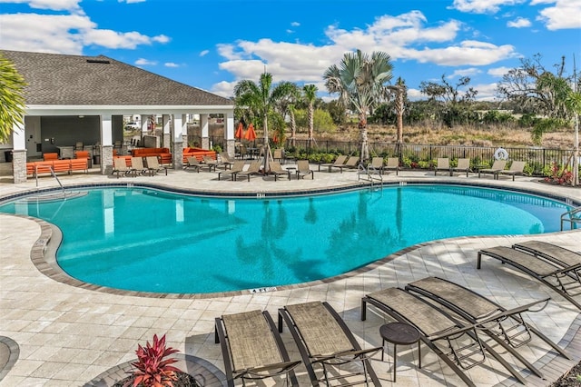 pool with a patio and fence