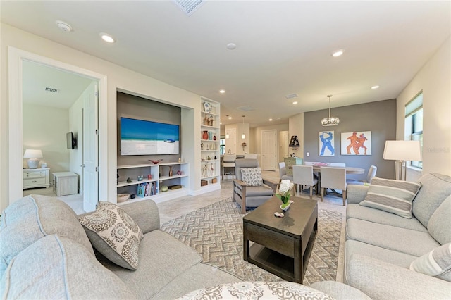 living room featuring visible vents, recessed lighting, and built in features