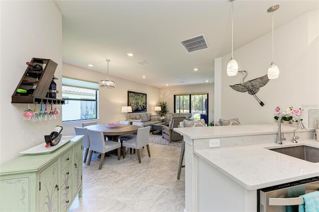 kitchen with a sink, visible vents, stainless steel dishwasher, and a wealth of natural light