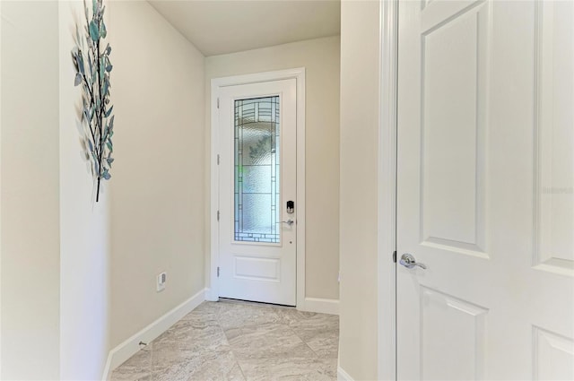 doorway featuring baseboards