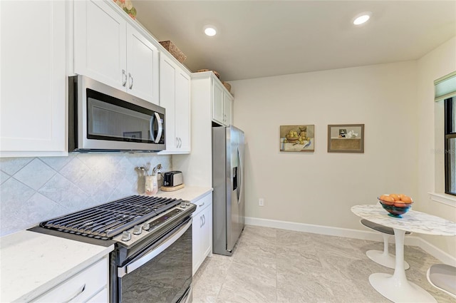 kitchen with white cabinetry, decorative backsplash, and appliances with stainless steel finishes