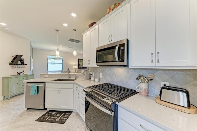 kitchen featuring visible vents, appliances with stainless steel finishes, a peninsula, white cabinets, and a sink