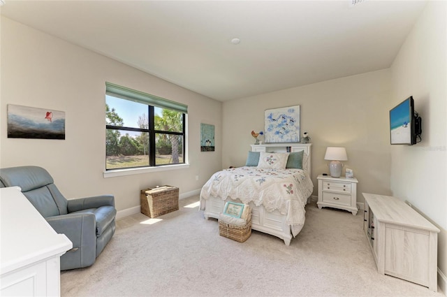 bedroom featuring light carpet and baseboards