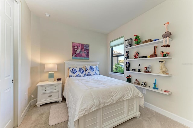 bedroom with baseboards and light colored carpet