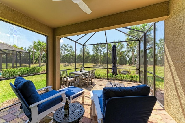 view of patio / terrace with glass enclosure, an outdoor hangout area, and ceiling fan