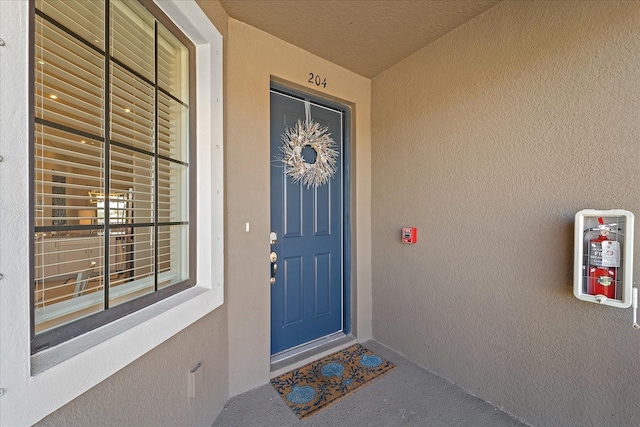 doorway to property with crawl space and stucco siding