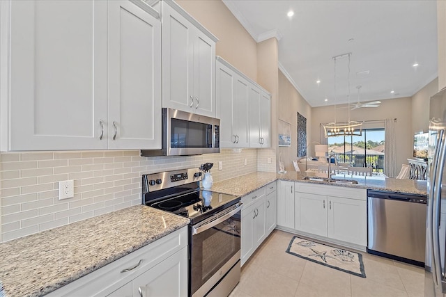 kitchen featuring backsplash, ornamental molding, appliances with stainless steel finishes, and a sink