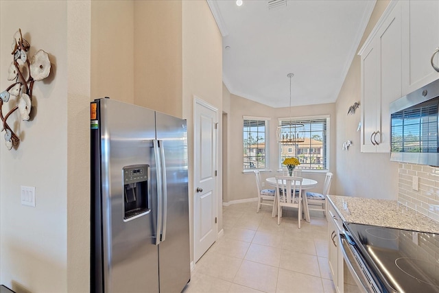 kitchen featuring ornamental molding, light stone counters, appliances with stainless steel finishes, white cabinets, and light tile patterned floors