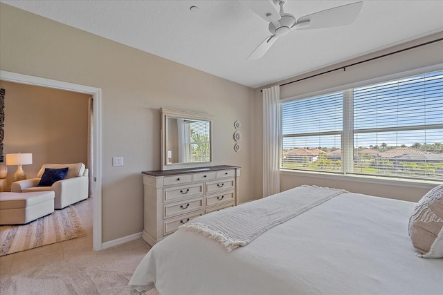 bedroom featuring baseboards, light carpet, ceiling fan, and vaulted ceiling