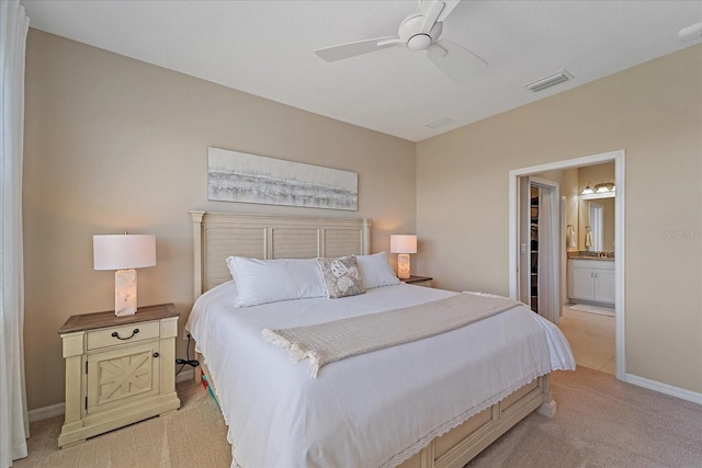 bedroom with visible vents, connected bathroom, baseboards, ceiling fan, and light carpet