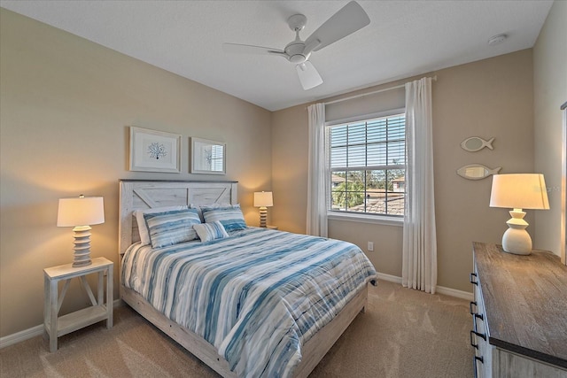 bedroom with light colored carpet, baseboards, and ceiling fan