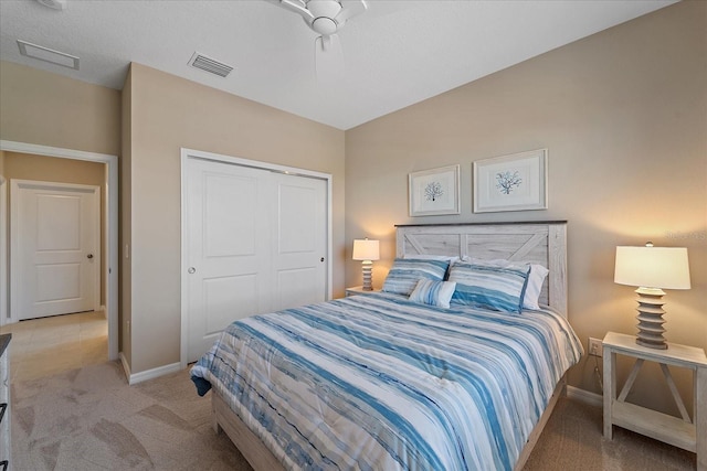 bedroom featuring light colored carpet, visible vents, a closet, and baseboards