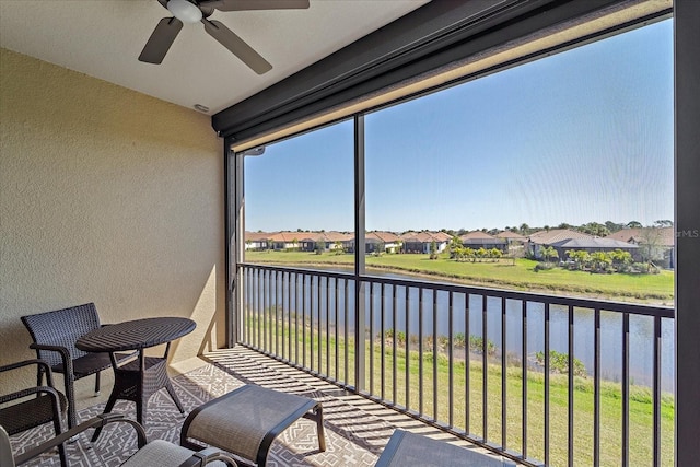 sunroom with a water view and a residential view